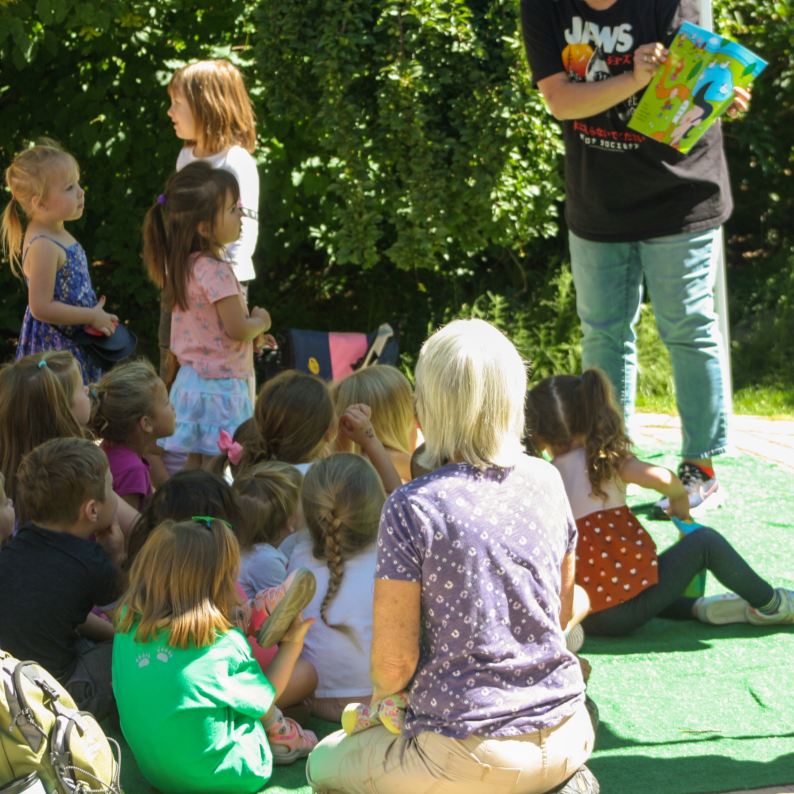 a group of young children watch a librarian read a book at May Arboretum Story Time